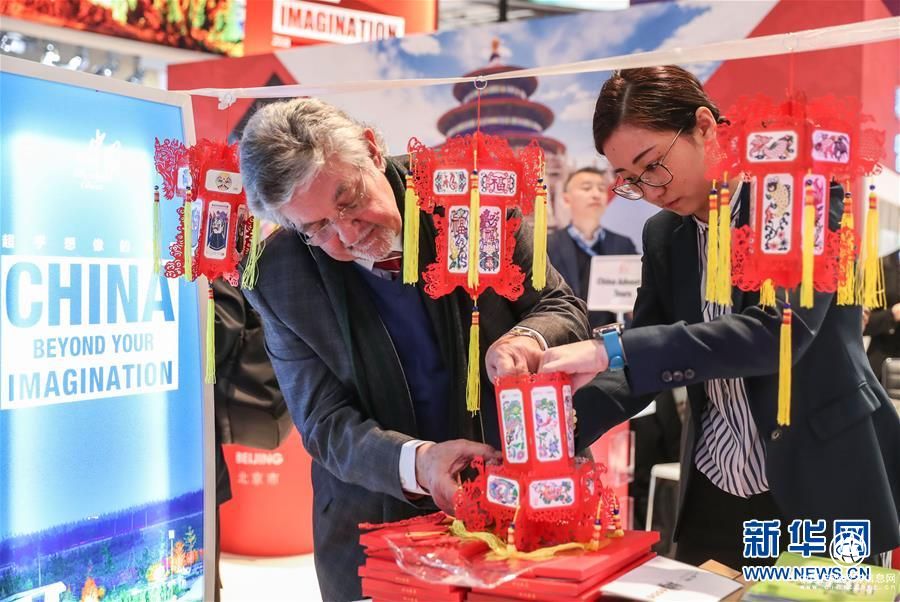 中國展區(qū)的工作人員為參觀者制作紙燈籠